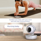 Woman exercising on a mat with a baby monitor displaying 'Morning baby' text.