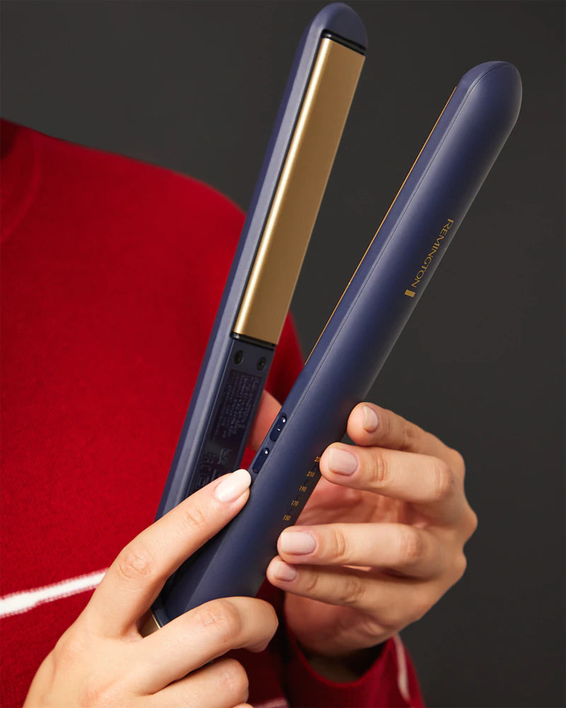 Blue hair straightener held by a person with a red garment in the background