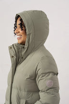 Person wearing a green puffer jacket with a hood on a white background