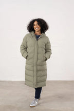 Woman wearing a long puffer coat against a white background