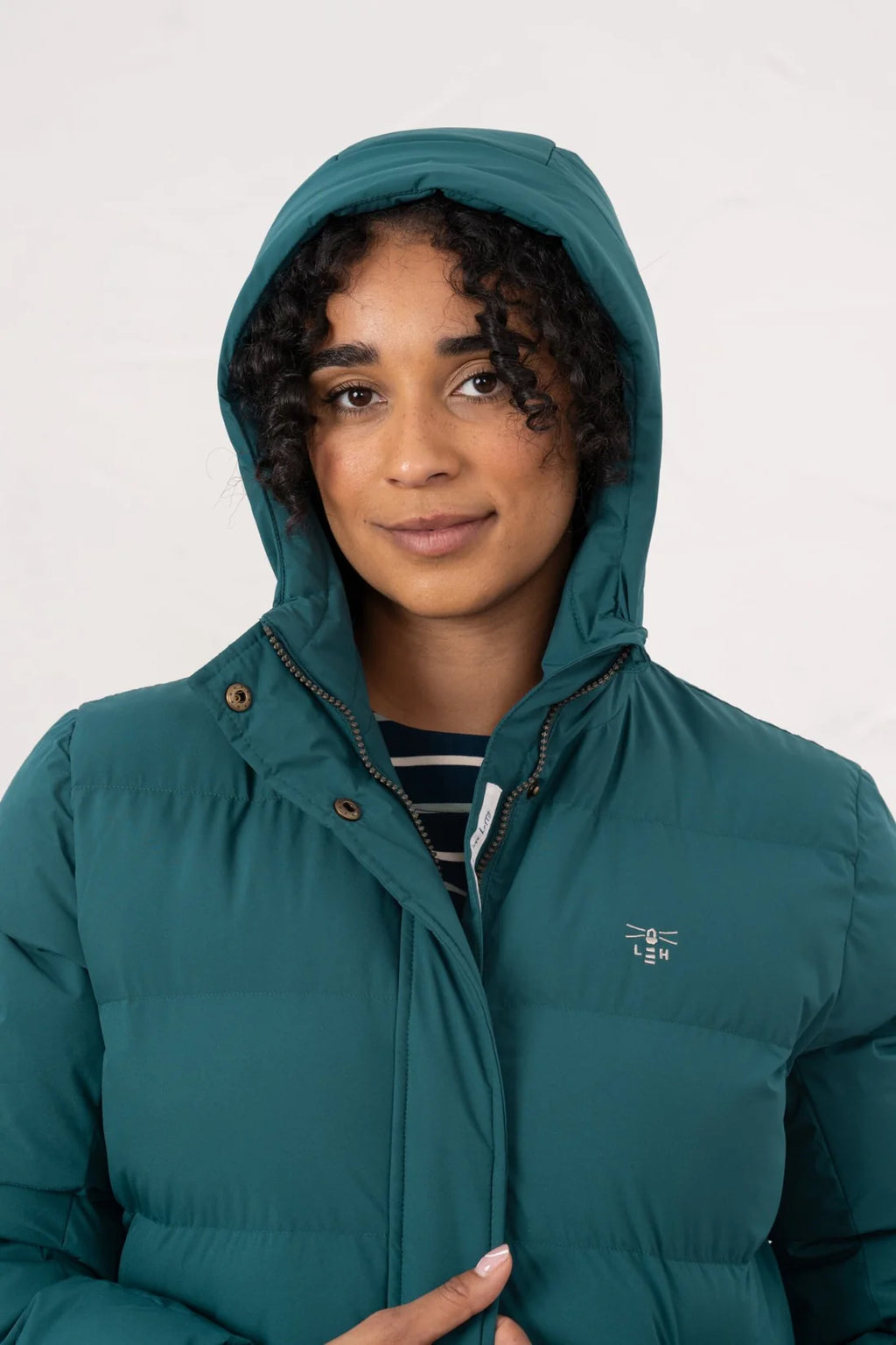 Person wearing a teal puffer jacket on a white background