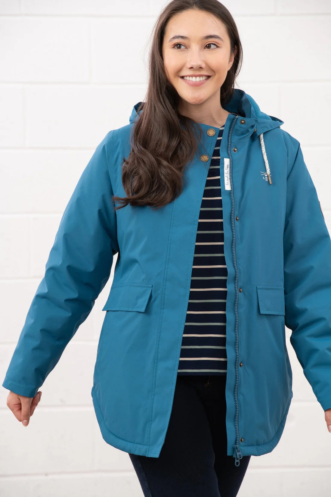 Woman wearing a blue raincoat against a white background