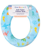 First Steps brand soft toilet trainer seat in light blue with a colorful ocean-themed pattern of sea creatures, shown with its product packaging label.