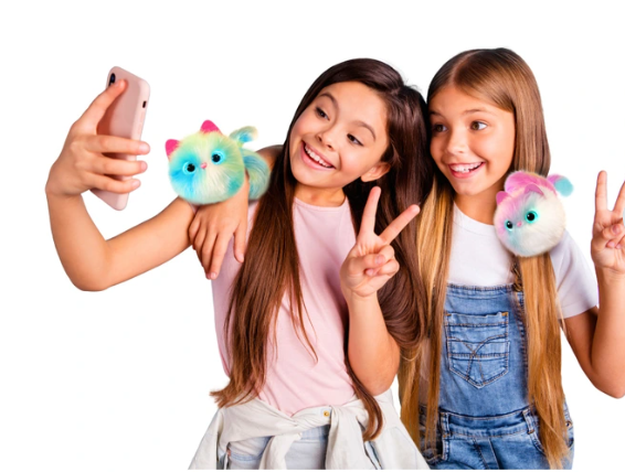 Two children with colorful pomsie toys taking a selfie on a white background