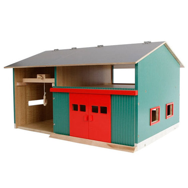 Colorful toy barn with a red door and green sides on a white background